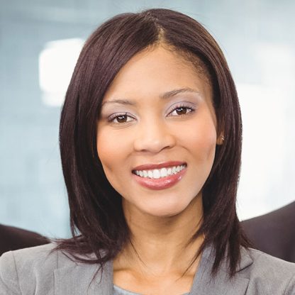 a woman in a gray shirt is smiling at the camera.